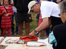 Salmon prep competition at Skidegate Days - a steady hand and a very sharp knife required ~ Photo Credit: R.Watkiss
