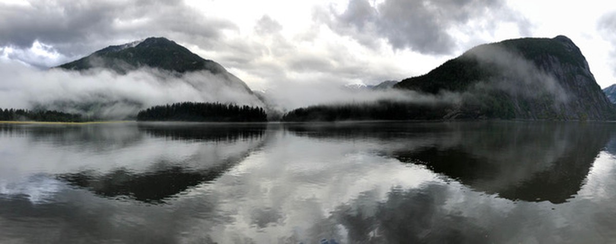Reflections of mist shrouded fiord